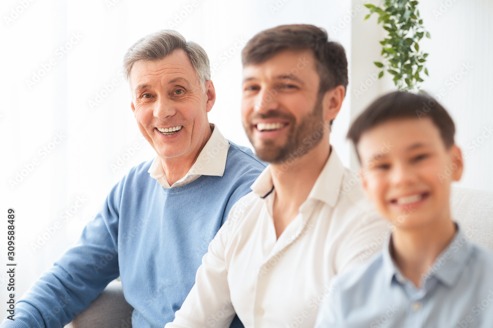 Elderly Man With Middle-Aged Son And Grandson Sitting On Couch Elderly Man With Middle-Aged Son And Grandson Sitting On Couch