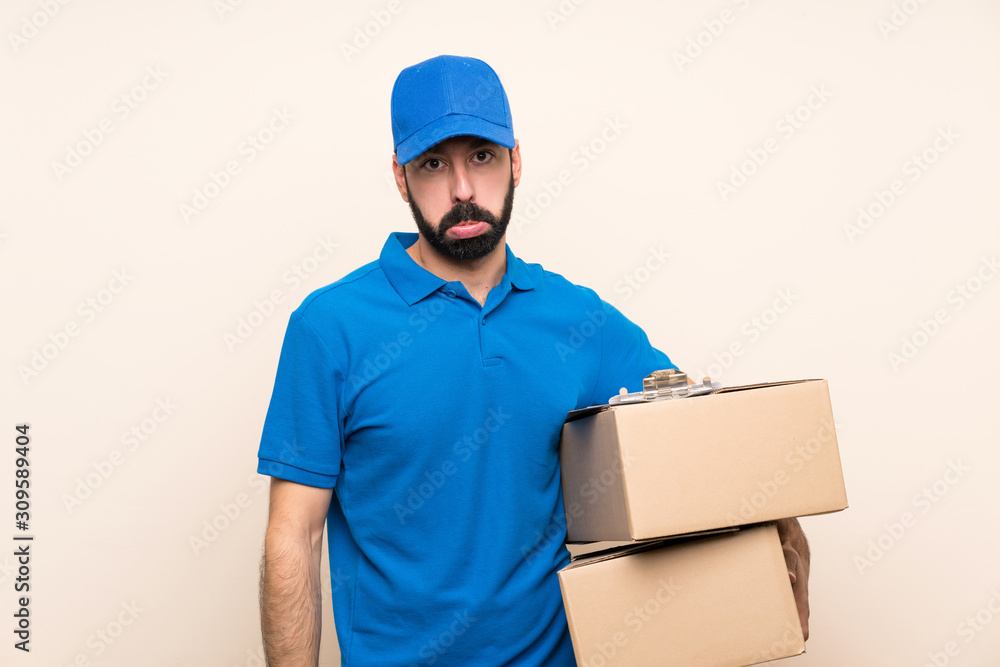 Delivery man with beard over isolated background with sad and depressed expression Delivery man with beard over isolated background with sad and depressed expression