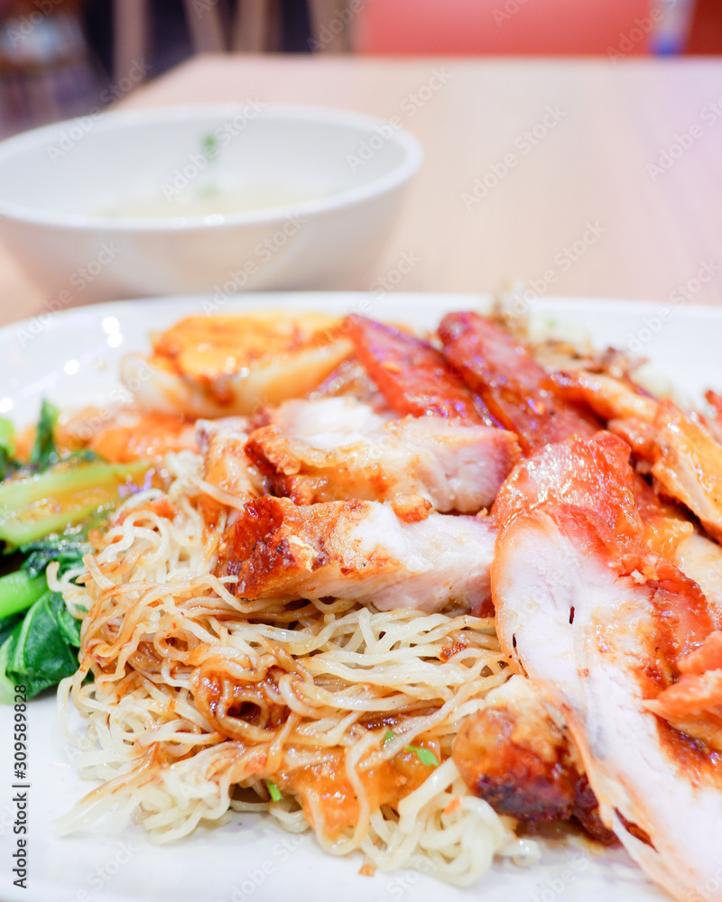 Wantan noodles, a Cantonese Chinese cuisine served dry with soy sauce and roast pork Wantan noodles, a Cantonese Chinese cuisine served dry with soy sauce and roast pork