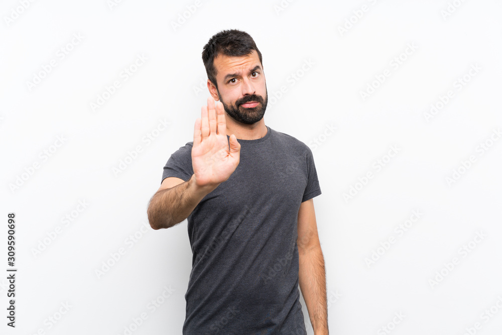 Fototapeta premium Young handsome man over isolated white background making stop gesture
