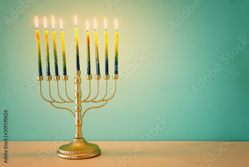 Religion image of jewish holiday Hanukkah background with brass menorah (traditional candelabra) and candles