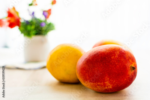 fresh red and yellow mangos on table 