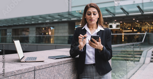 Photography Puzzled entrepreneur browsing smartphone on street