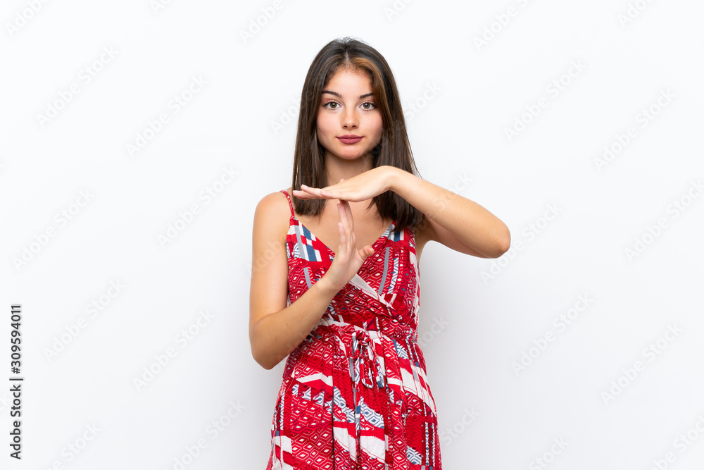 Caucasian girl in red dress over isolated white wall making time out gesture Caucasian girl in red dress over isolated white wall making time out gesture
