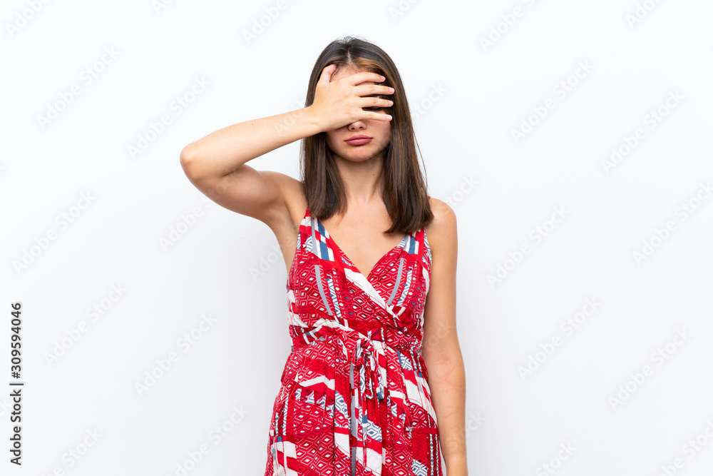 Caucasian girl in red dress over isolated white wall covering eyes by hands. Do not want to see something Caucasian girl in red dress over isolated white wall covering eyes by hands. Do not want to see something