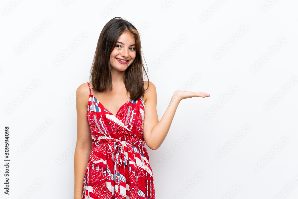 Caucasian girl in red dress over isolated white wall holding copyspace imaginary on the palm to insert an ad Caucasian girl in red dress over isolated white wall holding copyspace imaginary on the palm to insert an ad