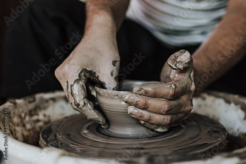 Hands of craftsman artist working on pottery wheel.Selective Focus .