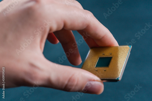 Hand holding CPU. Coonsumer 7 nanometer desktop CPU,  processoor. Informatic chip, PC component.
