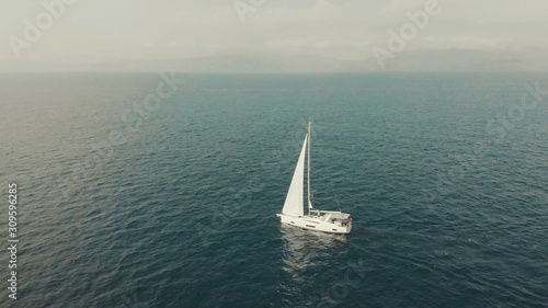 Aerial View of yacht in ocean. Drone footage of yachting around Balearic islands in the mediterranean sea. Silhouette of people © tol_u4f
