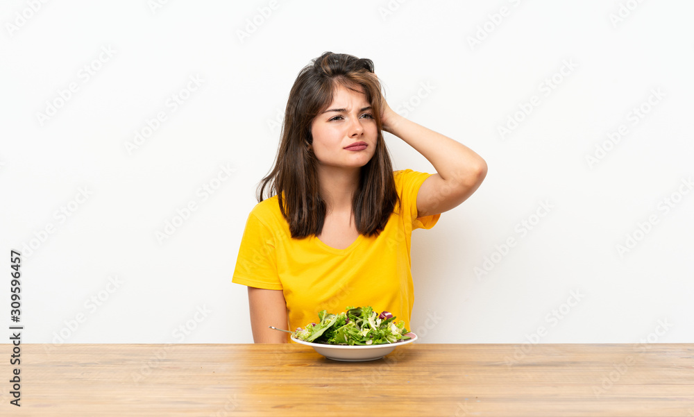Caucasian girl with salad having doubts and with confuse face expression