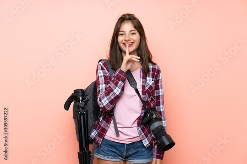 Young photographer girl over isolated pink background doing silence gesture