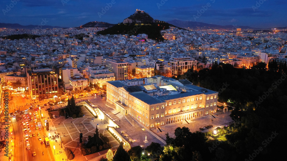 Aerial drone night shot of iconic illuminated Greek Parliament building as seen during Christmas holiday, Athens, Attica, Greece
