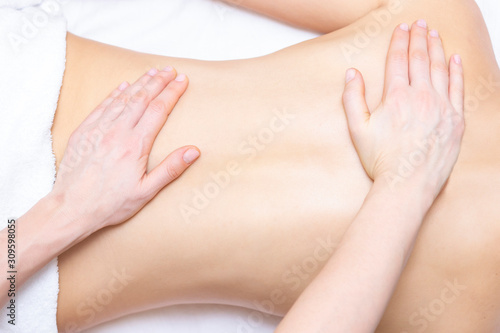 Fototapeta Naklejka Na Ścianę i Meble -  Massage and body care. Spa woman body massage with hands treatment. Stretching the back muscles. Woman having massage at the spa for beautiful girl