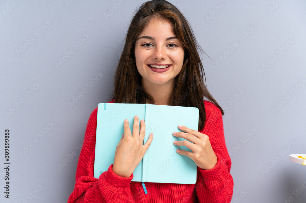 Young woman sitting on the floor and holding a notebook Young woman sitting on the floor and holding a notebook