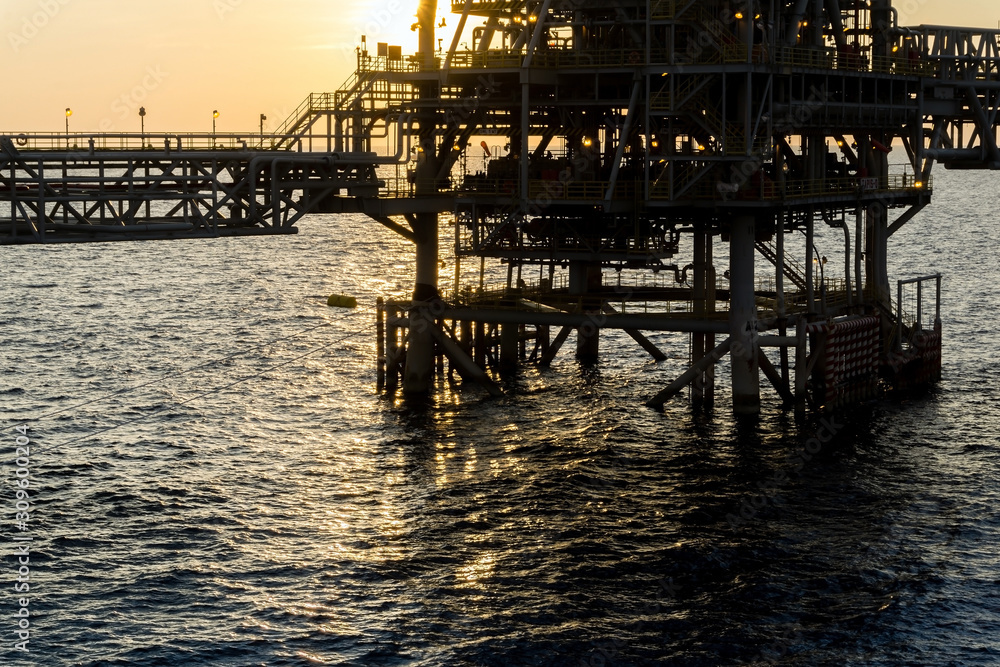 Silhouette of an oil production platform at oil field during sunset