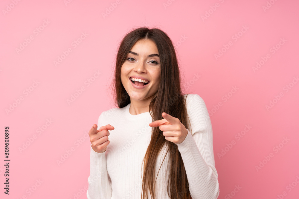 Young woman over isolated pink background points finger at you Young woman over isolated pink background points finger at you