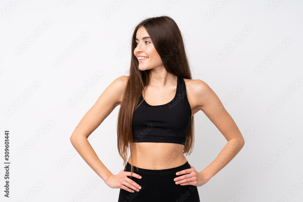 Young sport woman over isolated white background posing with arms at hip and looking side