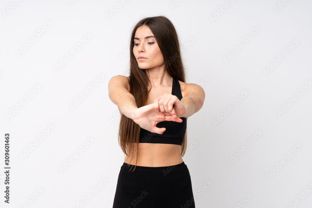 Young sport woman over isolated white background stretching arm