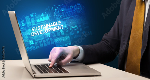 Businessman working on laptop with SUSTAINABLE DEVELOPMENT inscription, cyber technology concept