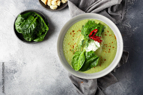 Vegetarian Green diet cream soup with broccoli and spinach, croutons on a marble gray background. Image with  copy space, top view