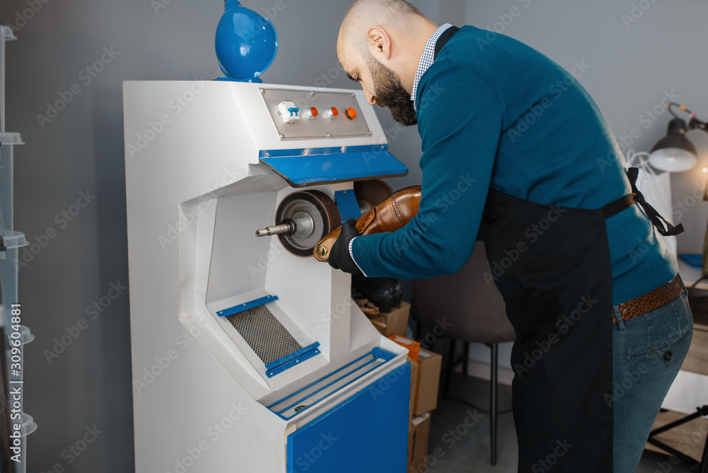 Shoemaker processes the shoe on emery machine Shoemaker processes the shoe on emery machine