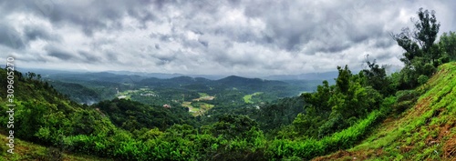 A landscape panorama of green hills with cloudy sky on the background in Coorg, India.