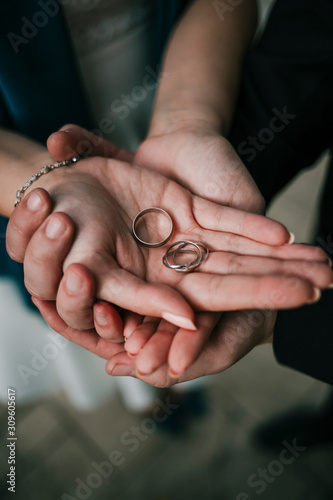 Lovely couple holding wedding rings