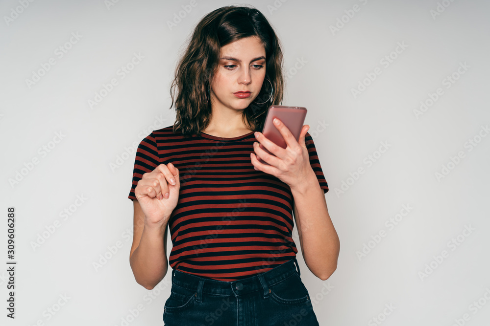 Young beautiful woman browsing smartphone posing in studio Young beautiful woman browsing smartphone posing in studio