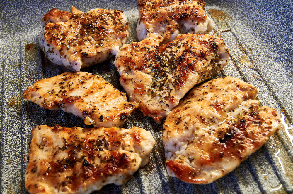 pieces of fried chicken breast. Grilled poultry steak cooked on a grill pan