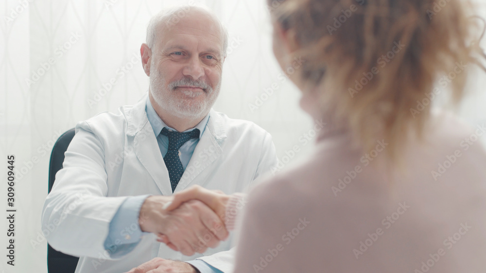 Fototapeta premium Doctor and patient shaking hands in the office