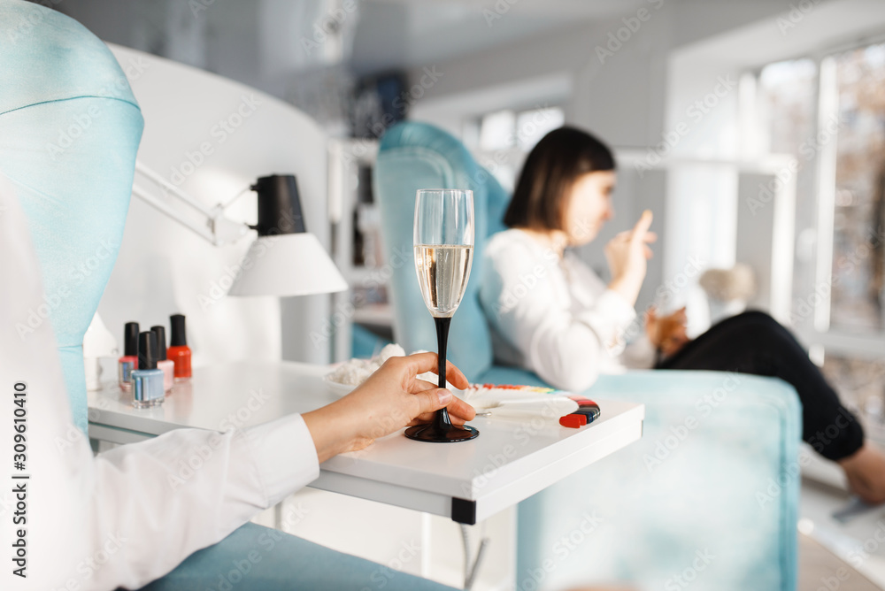 Two women with champagne in beauty salon