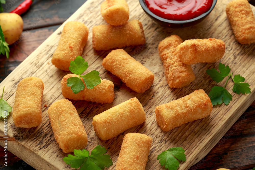 Naklejka premium Homemade Potato Croquettes with dipping sauce on wooden board