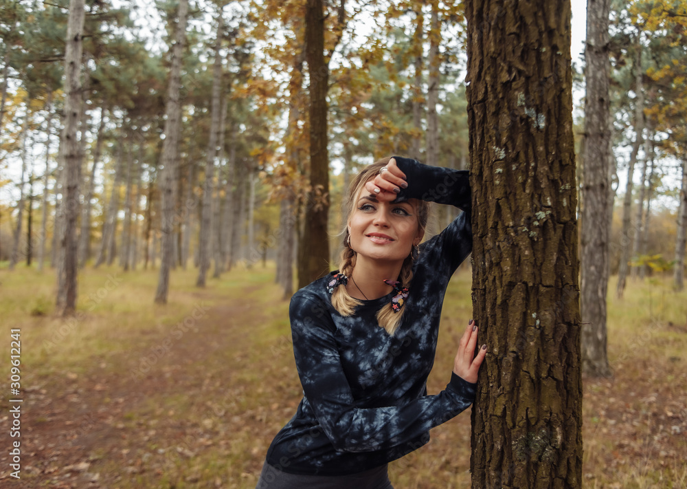 Young tired fit woman in sportswear leaned on a tree after an intense jog in the autumn forest. Healthy lifestyle concept. Outdoor workout Young tired fit woman in sportswear leaned on a tree after an intense jog in the autumn forest. Healthy lifestyle concept. Outdoor workout