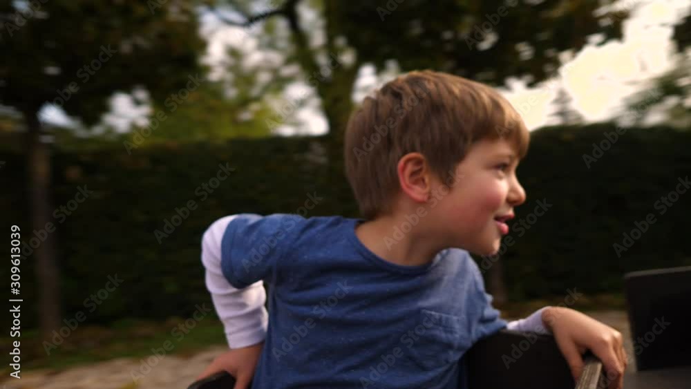 A mother spinning her son on a carousel in slow motion A mother spinning her son on a carousel in slow motion