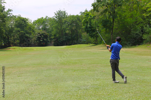 Golfer putting golf into the hole in beautiful golf course. The evening golf course with sunset in thailand