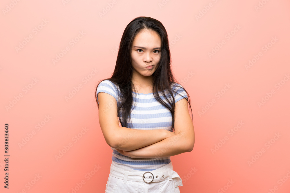 Teenager asian girl over isolated pink background feeling upset Teenager asian girl over isolated pink background feeling upset
