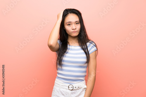 Teenager asian girl over isolated pink background with an expression of frustration and not understanding