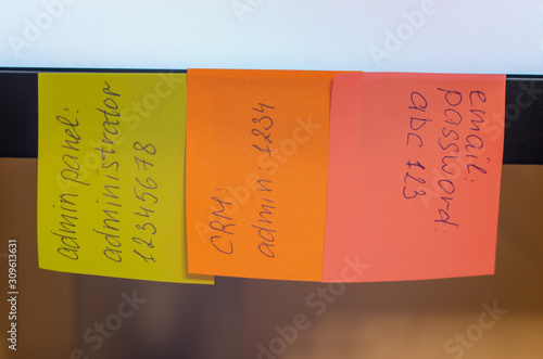 A very weak and widespread password is written on a sticker / stick note attached to a computer monitor. Password Security Weakness Concept. Typical information security failures. Bad password policy.