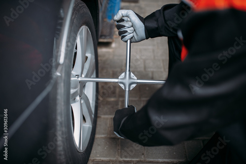 Mechanic unscrews the wheel in tire service