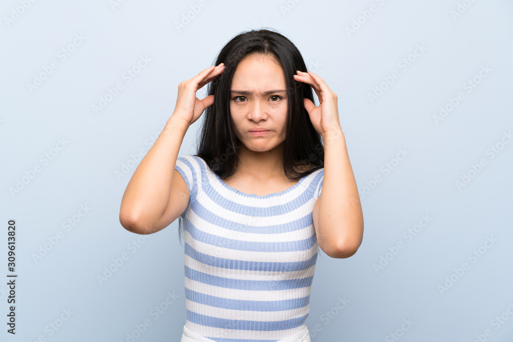 Teenager asian girl over isolated blue background unhappy and frustrated with something. Negative facial expression Teenager asian girl over isolated blue background unhappy and frustrated with something. Negative facial expression