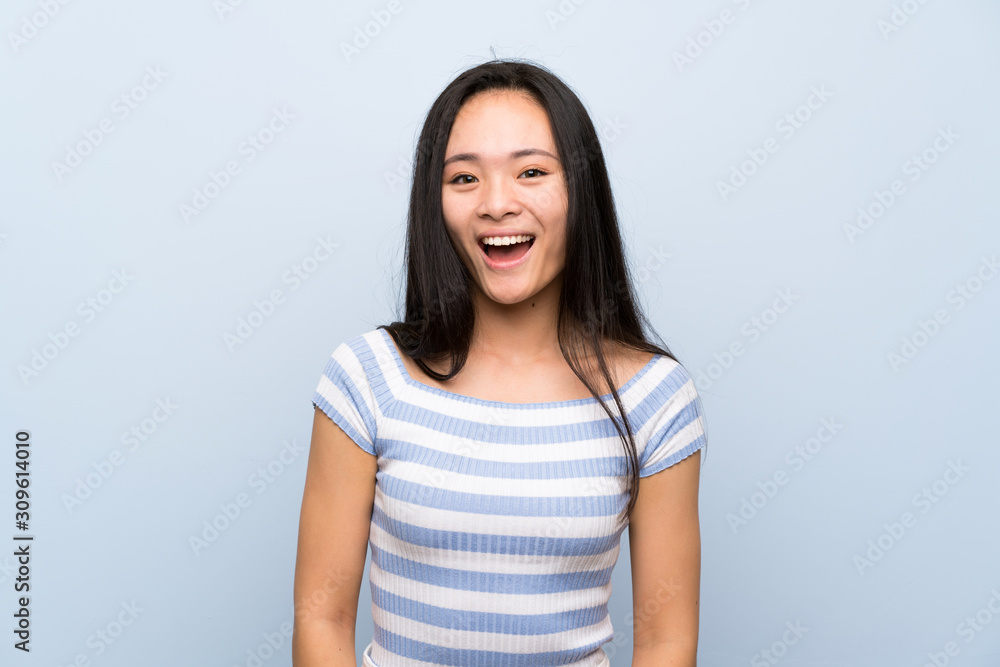 Teenager asian girl over isolated blue background with surprise facial expression Teenager asian girl over isolated blue background with surprise facial expression