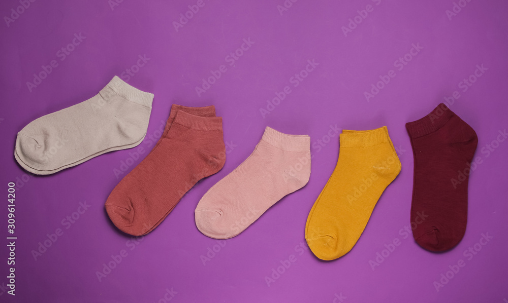 Set of colored socks on purple background. Top view Set of colored socks on purple background. Top view