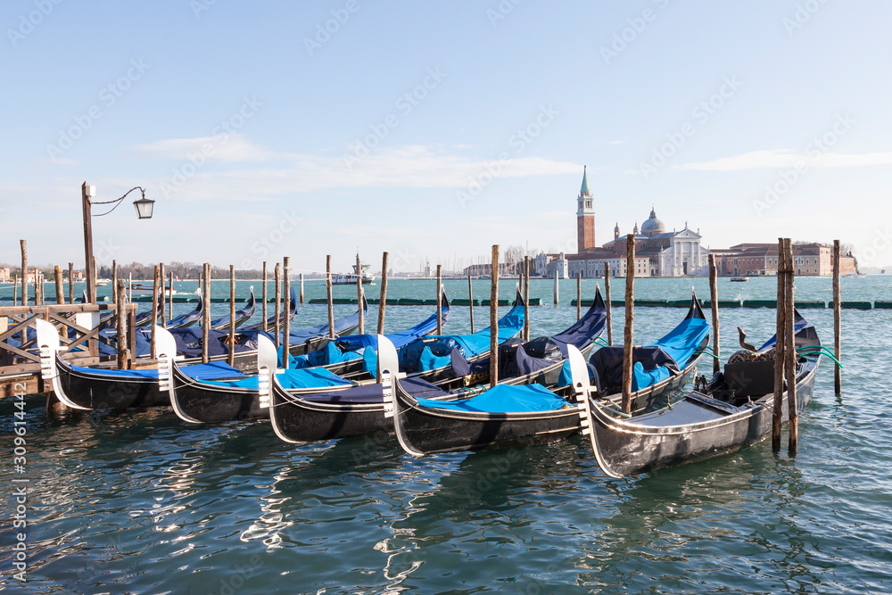 Gondolas moored in St Marks Basin at San Marco in morning light  with San Giorgio Maggiore in the background across the lagoon