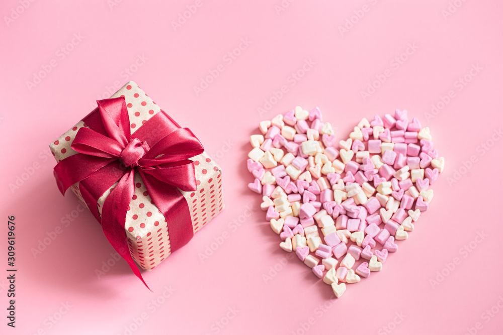 Fototapeta premium The concept of Valentine's day. Gift box with red bow on pink background.