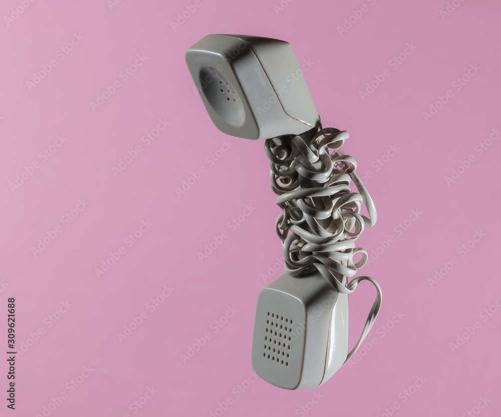 Retro telephone handset wrapped cable on pink pastel background Retro telephone handset wrapped cable on pink pastel background