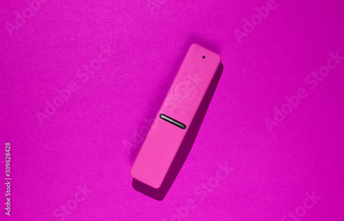 TV remote in a silicone case on pink background.
