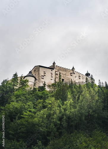 Hohenwerfen Castle is a medieval rock Alpine castle and history museum near Salzburg, Austrian Alps, Austria. It is surrounded by pine forests. Castle view on a rainy summer evening at sunset