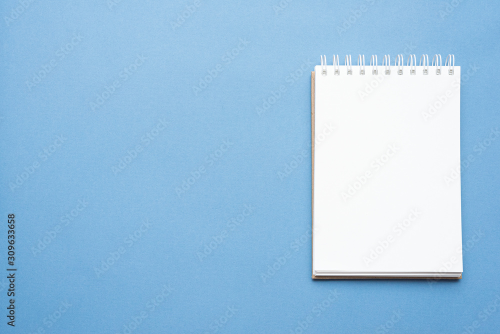 Blank page notepad with copy space on blue top view background. Blank page notepad with copy space on blue top view background.