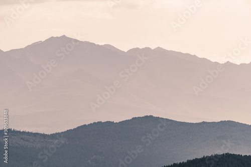 silhouette of mountain range in haze on horizon in mountain valley. Hiking in wild