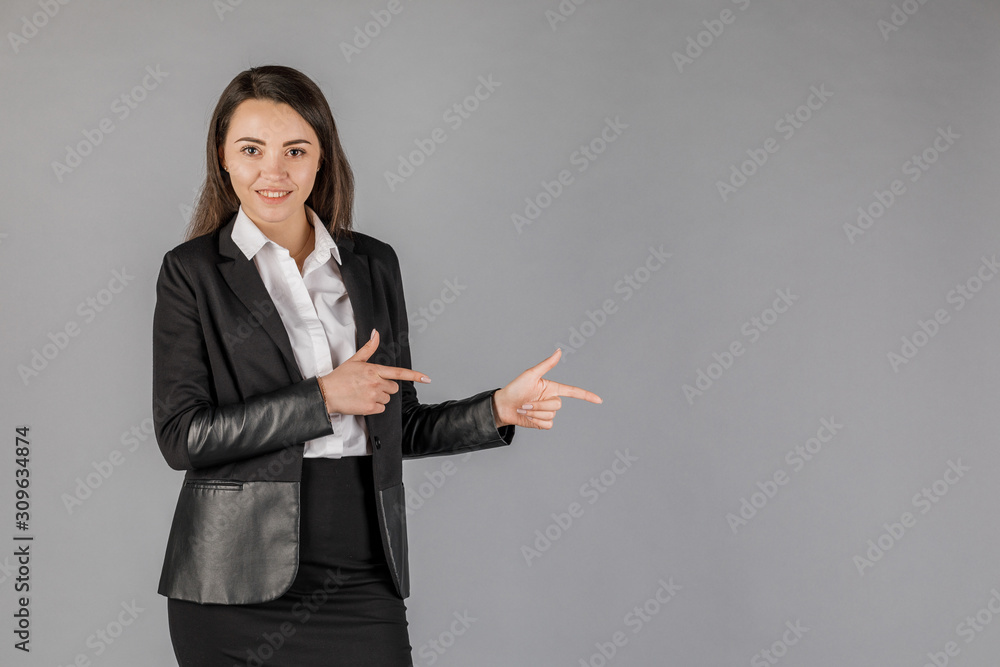 girl in black jacket on grey background pointing right girl in black jacket on grey background pointing right
